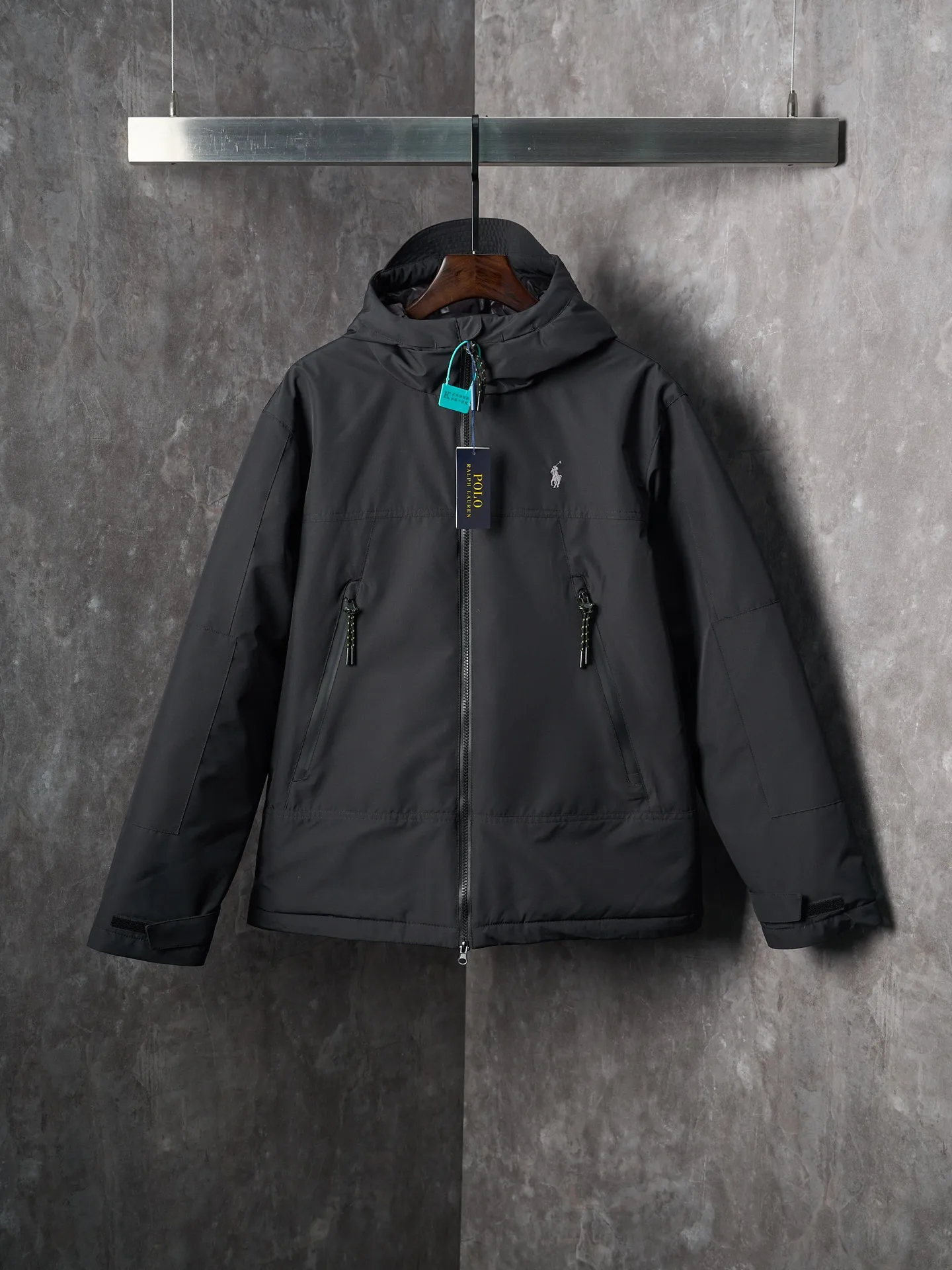 P980 Actual auction】Ralph Lauren/Ralph Lauren pony embroidered zipper hooded down jacket [Ready stock] S M L XL high-quality filling: 90 white duck down is selected, weighing 220g, ensuring excellent thermal insulation performance. After strict screening and processing, the velvet is not easy to be drilled, ensuring durability. The density of high-density nylon taffeta is about 210T-300T, with a smooth and slightly matte surface, excellent windproof and waterproof properties (with DWR water-repellent treatment), strong wrinkle resistance and easy care, in line with the positioning of American casual "durable and practical".  The inner lining is made of 100% polyamide. The high-density and tight weaving process prevents fine lint from getting out of the gaps in the fabric. The smooth surface improves the putting on and taking off experience, and the excellent wear and tear resistance ensures damage caused by frequent use, while the light and soft texture does not affect the overall weight.  The classic jacket has a slightly loose fit, slightly dropped shoulder line (shoulder width is 1-2cm wider than the standard fit), is hip-length, and has slightly tapered straight sleeves, taking into account both freedom of movement and casual style.  The adjustable Velcro on the cuffs allows you to freely adjust the tightness according to the thickness of your wrist and personal preferences, effectively preventing cold wind from intruding, and improving the warmth performance.  In terms of storage, the two front zipper pockets are convenient for you to place frequently used items, and the zipper design ensures that items are not easily lost. A built-in pocket on the left side of the chest provides a safe storage space for some small private items.  The drawstring design at the hem allows you to adjust the shape of the jacket according to your body shape and dressing needs. Whether it is loose and casual or slim and neat, you can easily control it.  Embroidery technology: Polo horse logo on the left chest: flat satin stitch embroidery (satin embroidery), embroidery thread: 100% polyester high color fastness embroidery thread (the color number is consistent with the brand’s standard red color card), stitch density 12-15 stitches/cm, the outline of the horse logo is clear, and the details of the rider and horse are burr-free.  Embroidery positioning: precise positioning through the template (12cm from the neckline and 8cm from the placket) to ensure left and right symmetry and centering.